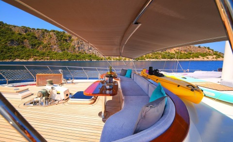 Sunlit sea view from the yacht deck with a shaded seating area and a table