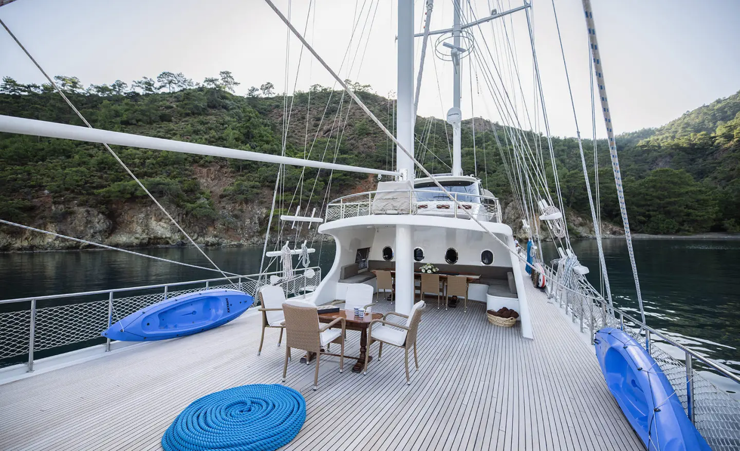 Kayhan 4 luxury gulet yacht on calm sunset sea with deck seating and masts