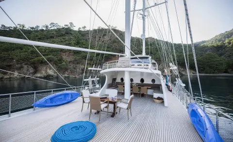Kayhan 4 luxury gulet yacht on calm sunset sea with deck seating and masts