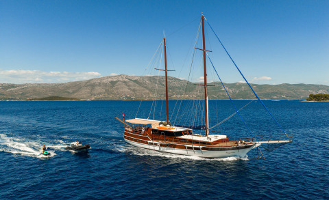 Elegant gulet sailing yacht on open sea with wooden hull and two masts
