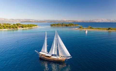 Two-masted sailing yacht on blue water with sails raised
