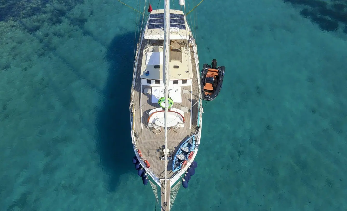 Gazella yacht anchored in turquoise water, top-down view from above