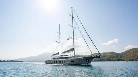 Sailing yacht De Love anchored in calm blue water under clear sky