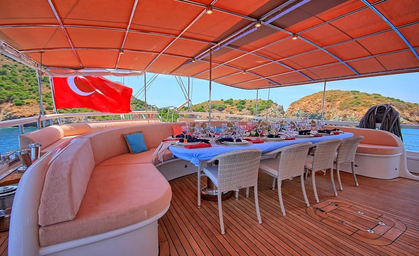 Aft deck of Queen Of Salmakis gulet with white seating and orange canopy