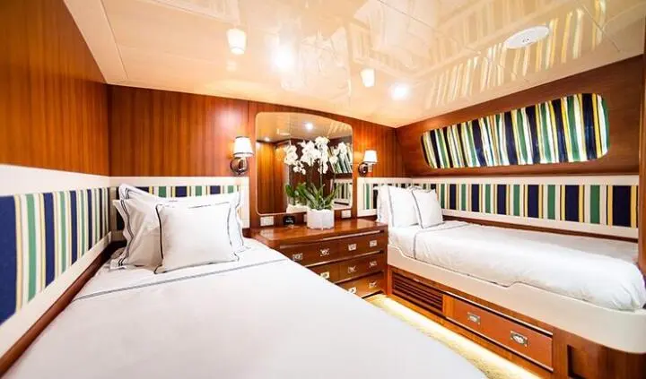 Twin cabin interior on Wind Of Fortune yacht with wooden berths and warm lighting