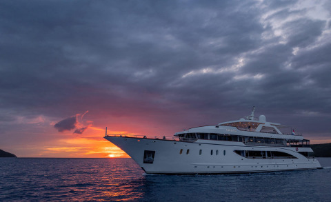 Large white yacht Cristal anchored on calm sea at sunset