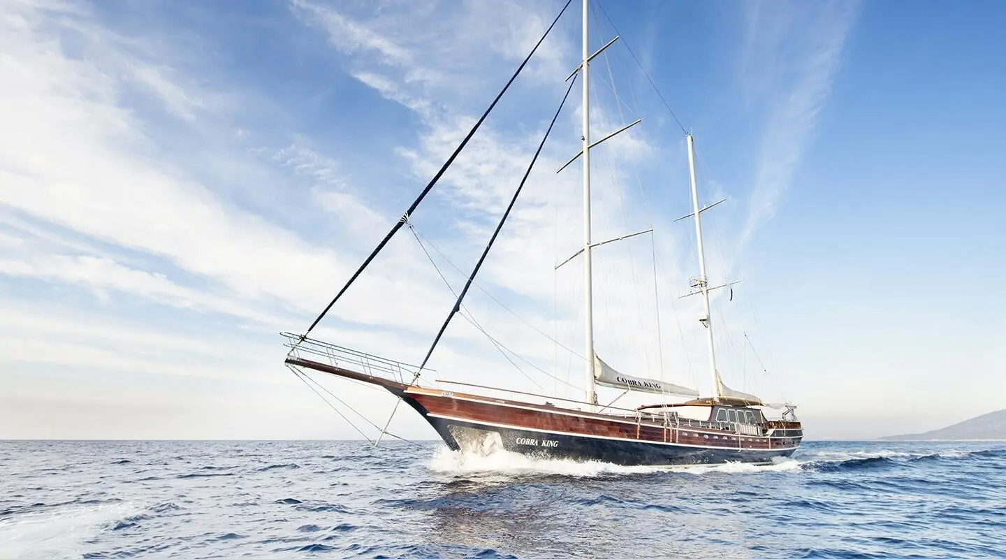 Sailing yacht Cobra King anchored on calm sea at sunset with rigging visible