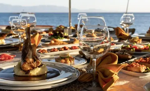 Guest dining on a Sunlit yacht deck with plates and drinks laid out