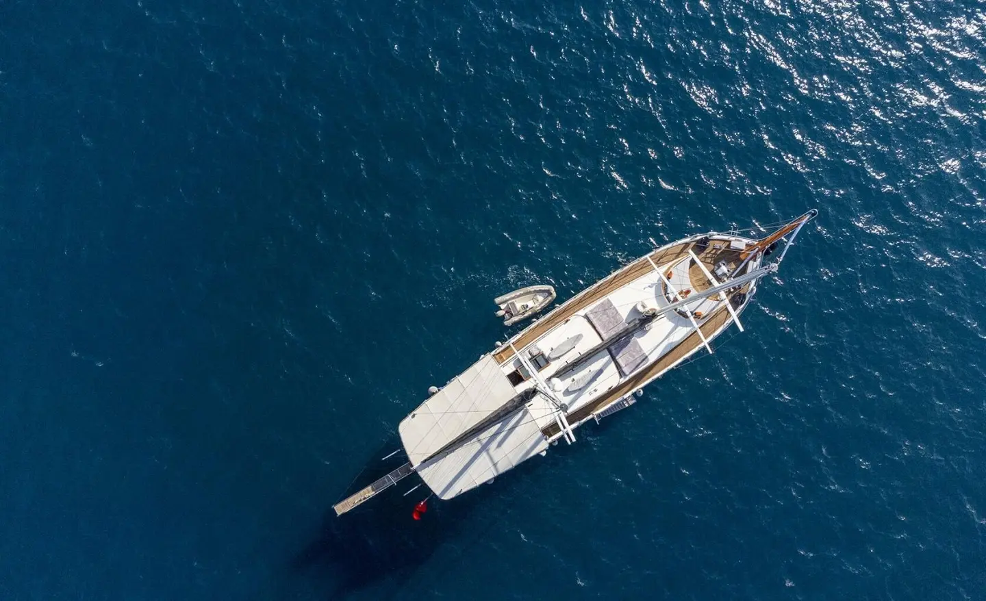 Top-down view of Diva Deniz luxury gulet anchored in calm blue water at sunset