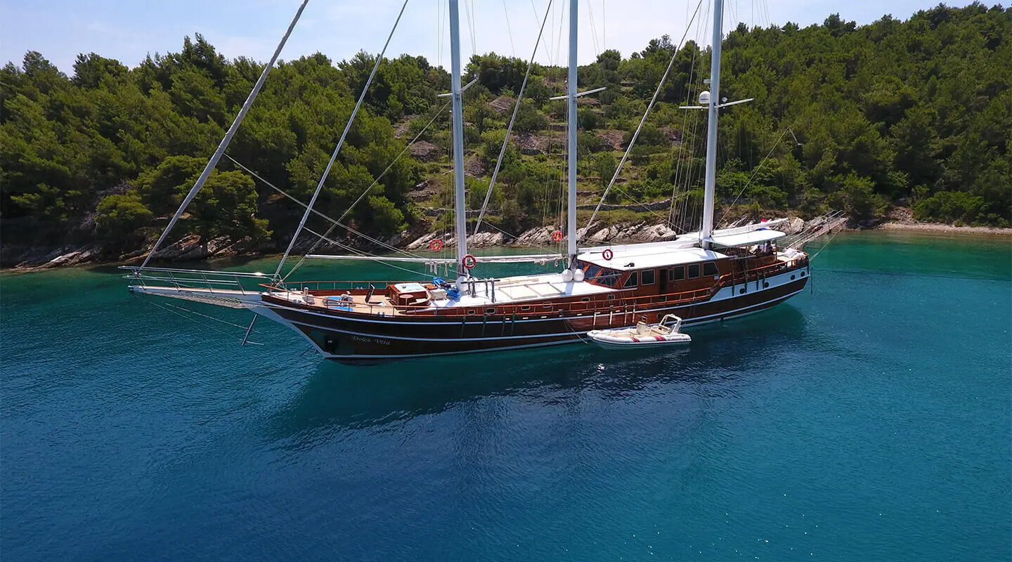 Dolce Vita luxury sailing yacht anchored in turquoise water at sunset
