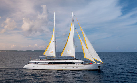 Two-masted white sailing yacht on open sea