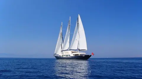 Three-masted sailing yacht Meira on blue sea with sails up