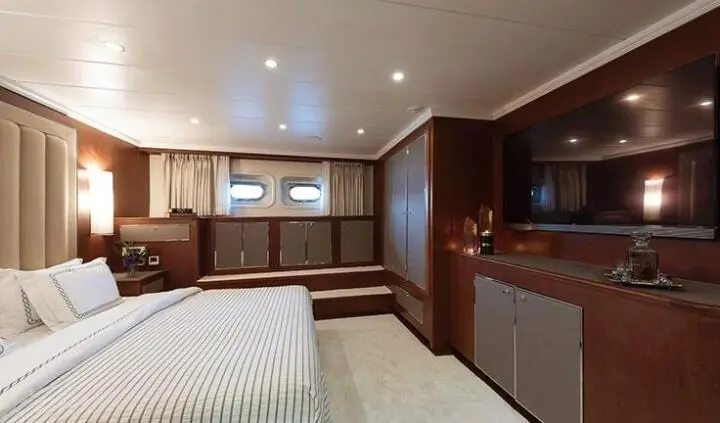 Master cabin with king bed, ensuite, wood cabinetry, bedside lamps, window view