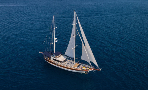 Luxury sailing yacht with two masts and large sails on blue sea