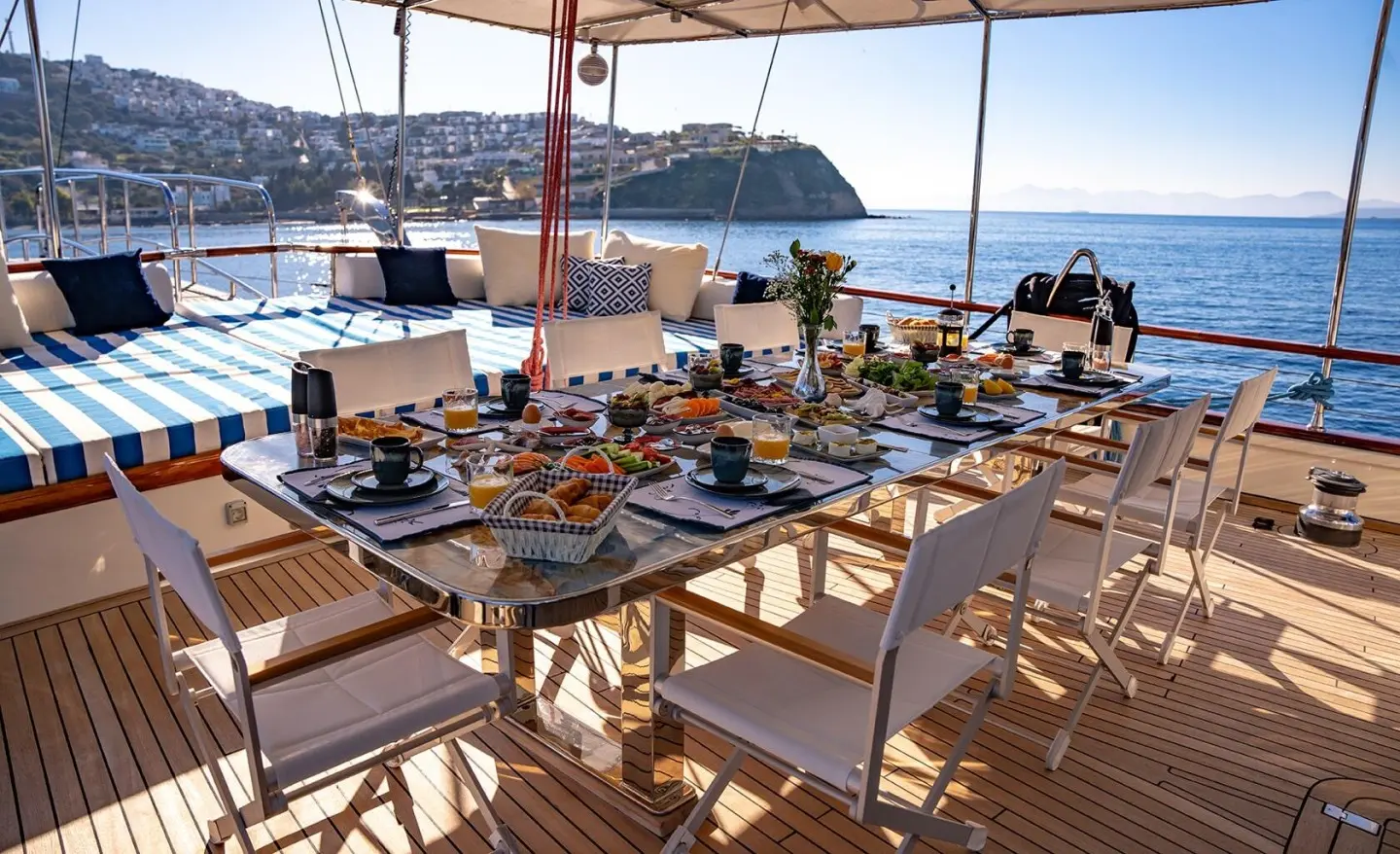 Double Eagle yacht at sunset with a long wooden dining table and guests