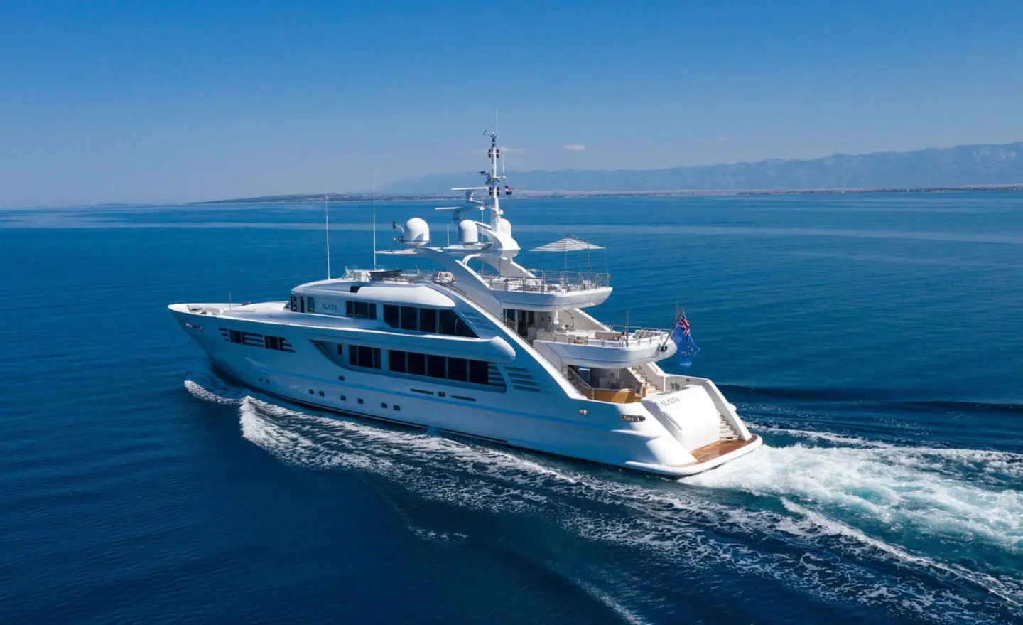 Alalya luxury yacht cruising on blue sea, white hull, wake