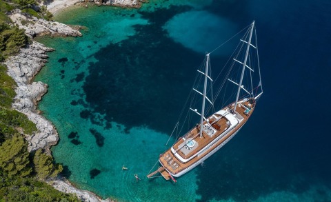 Love Story luxury sailing yacht anchored near turquoise rocky coastline