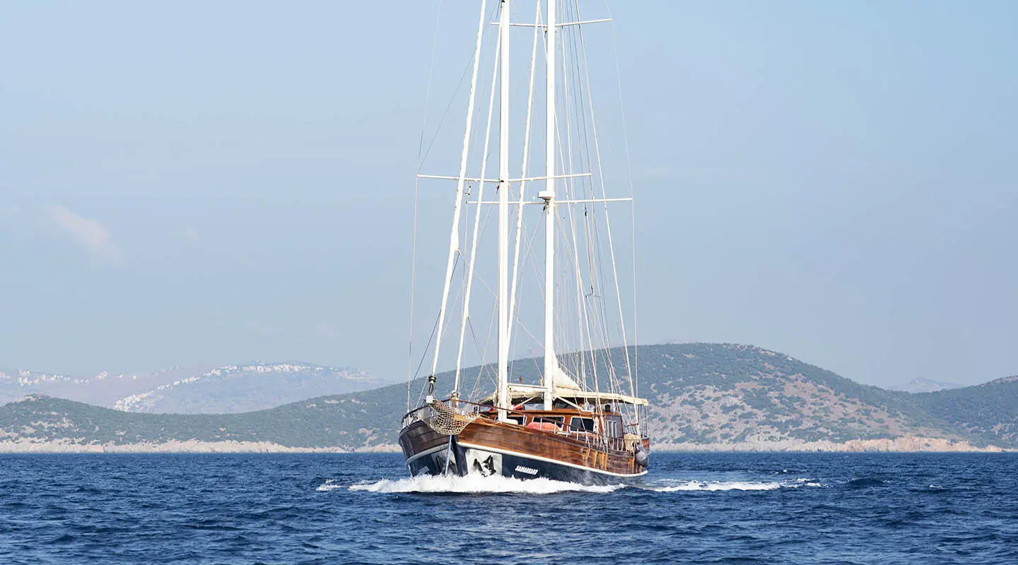 Yacht Samarkand sailing on blue sea with sails and gulls nearby
