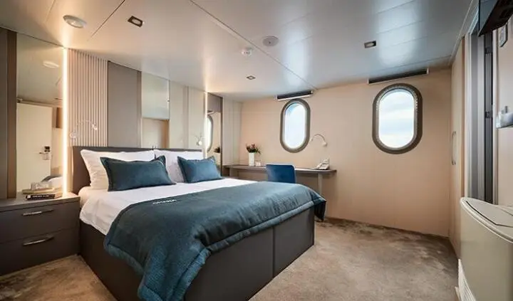 Master cabin aboard Ohana with king bed and ensuite view featuring portholes