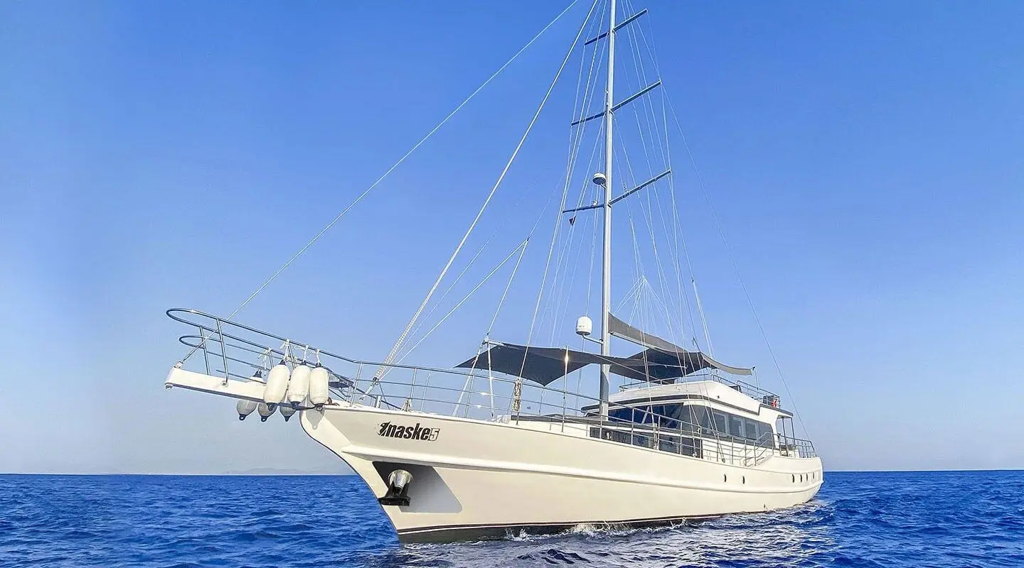 Gulet Maske 5 yacht anchored with sails and clear blue sea background