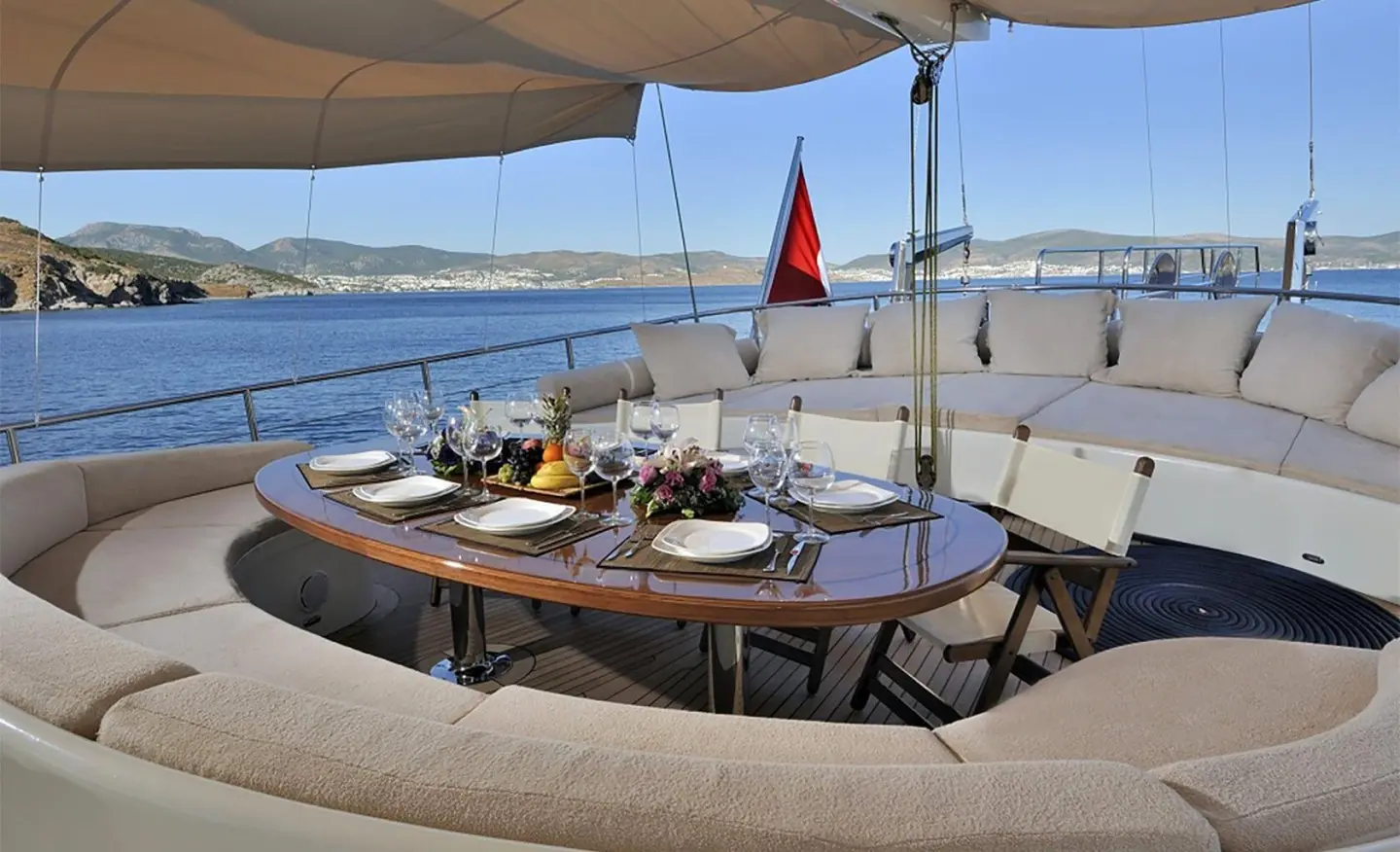 Dolce Mare yacht dining table set on deck at sunset with sea view