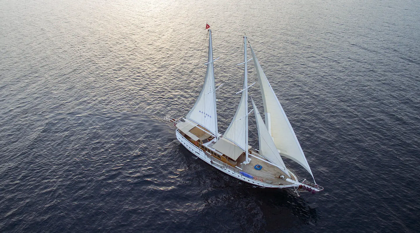 Kayhan 8 luxury gulet sailing at sunset, two masts over calm sea