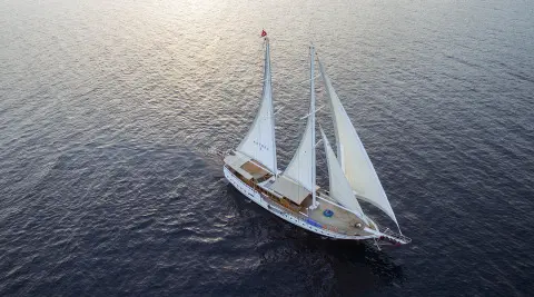 Kayhan 8 luxury gulet sailing at sunset, two masts over calm sea
