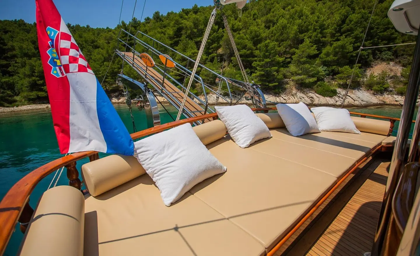 Dolce Vita gulet aft deck with tan cushioned seating and white pillows