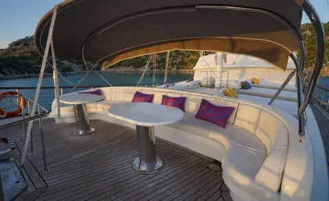 Prenses Esila luxury gulet deck seating area with purple cushions at sunset