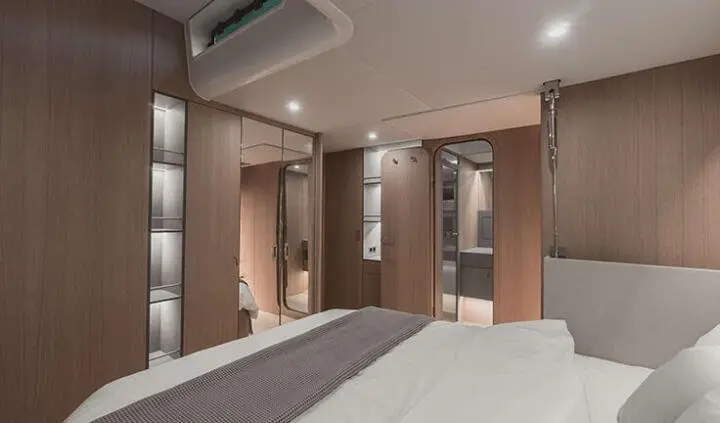 Interior cabin on Nadamas yacht with bed, curtains, and warm lighting visible