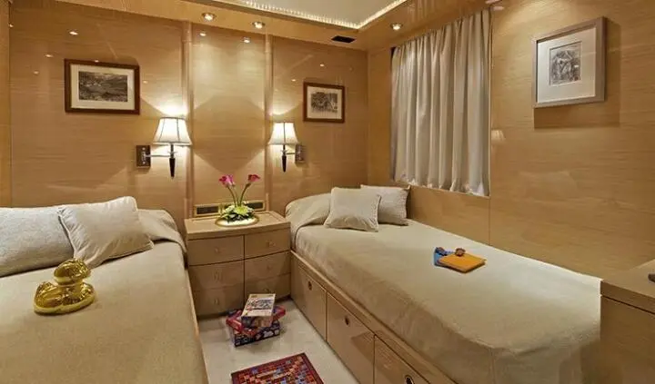 A luxurious yacht cabin with beige seating, wooden paneling, and soft lighting