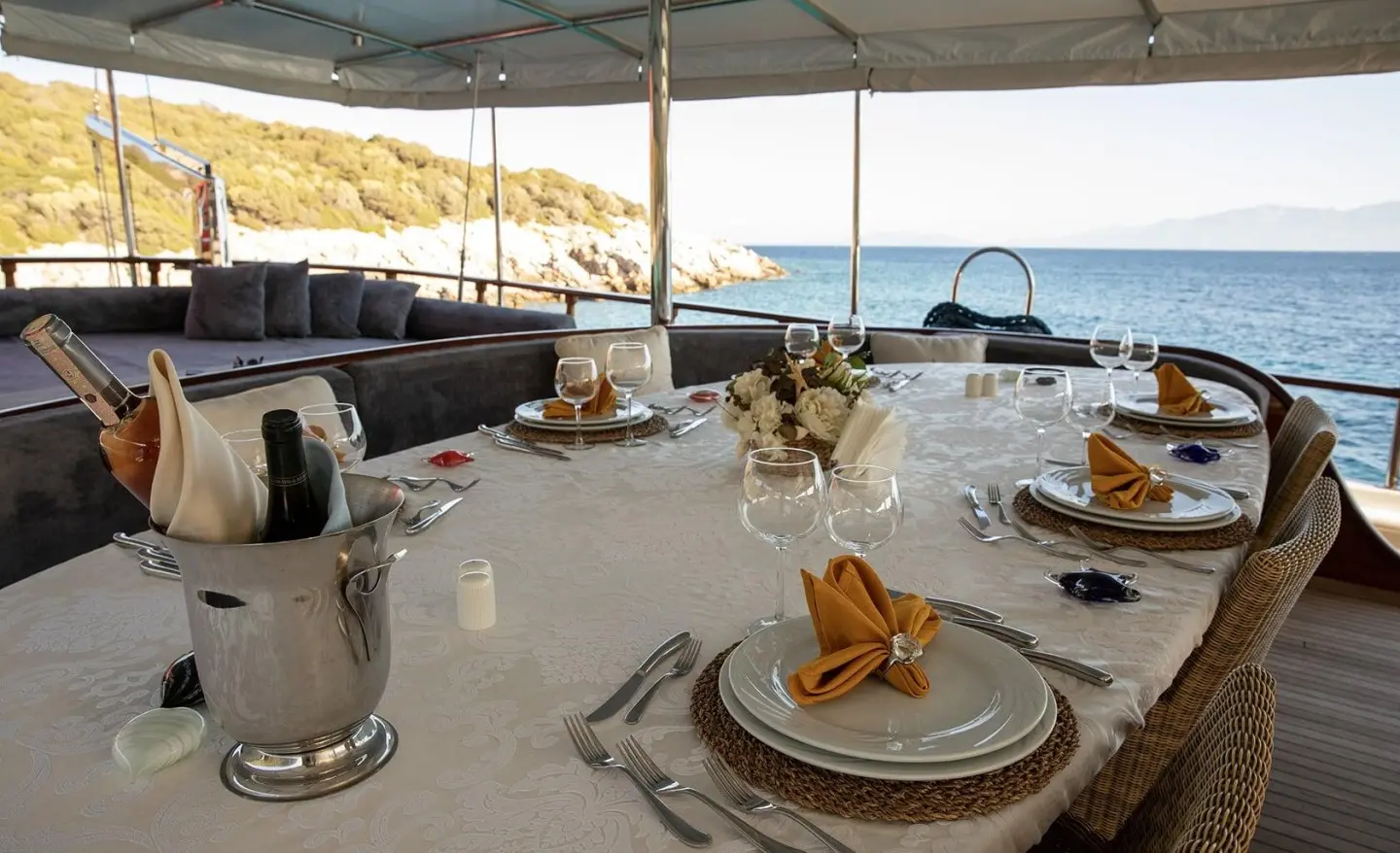 Arif Kaptan A yacht at sunset with dining table set on deck