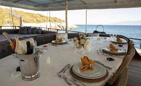 Arif Kaptan A yacht at sunset with dining table set on deck