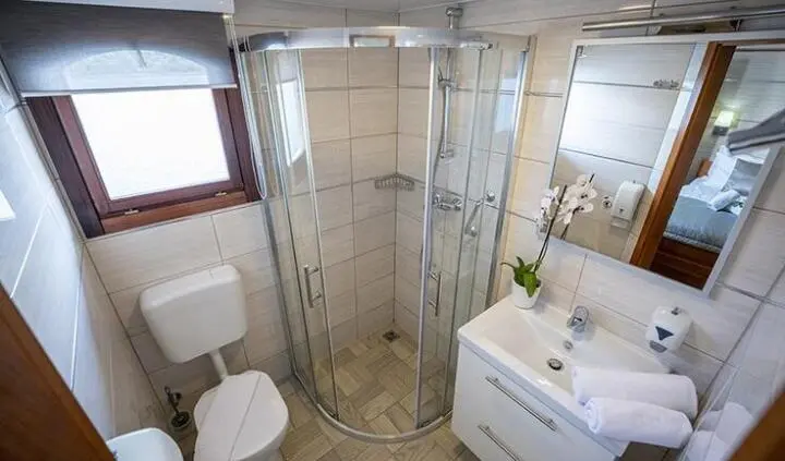 Cabin ensuite aboard Karizma yacht with curved shower enclosure and sink