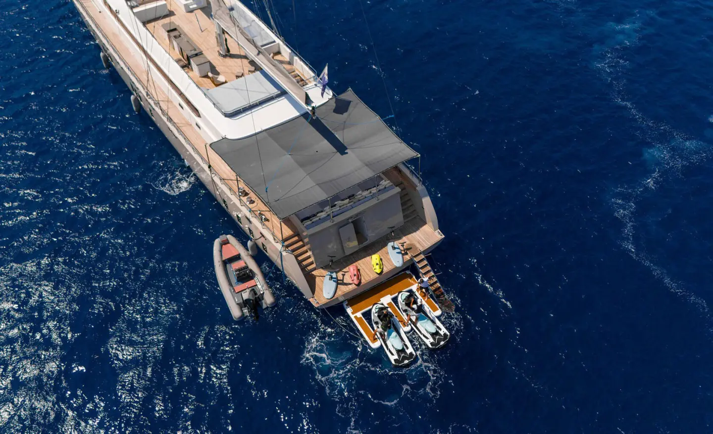 Top-down view of De Love luxury yacht anchored in dark blue water with deck seating