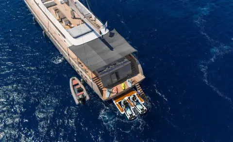Top-down view of De Love luxury yacht anchored in dark blue water with deck seating