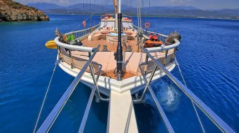 Bow of Queen Of Salmakis yacht at sunset with blue sea around
