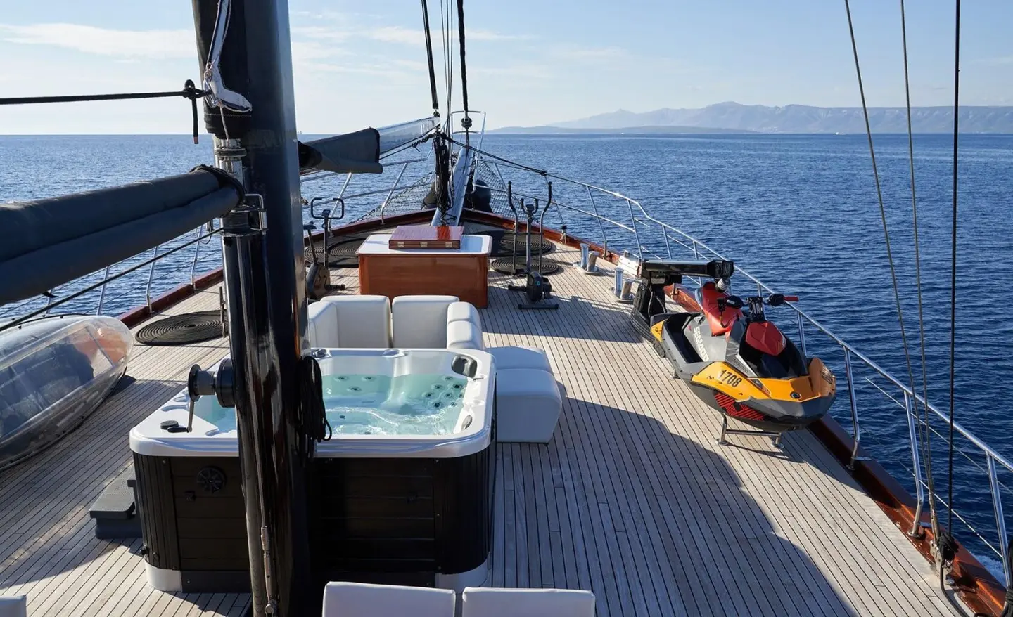 Stella Maris yacht deck at sunset with seating, loungers, and calm sea view