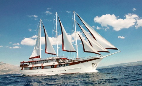 Luxury sailing yacht Amorena on blue sea with white and red-brown hull details