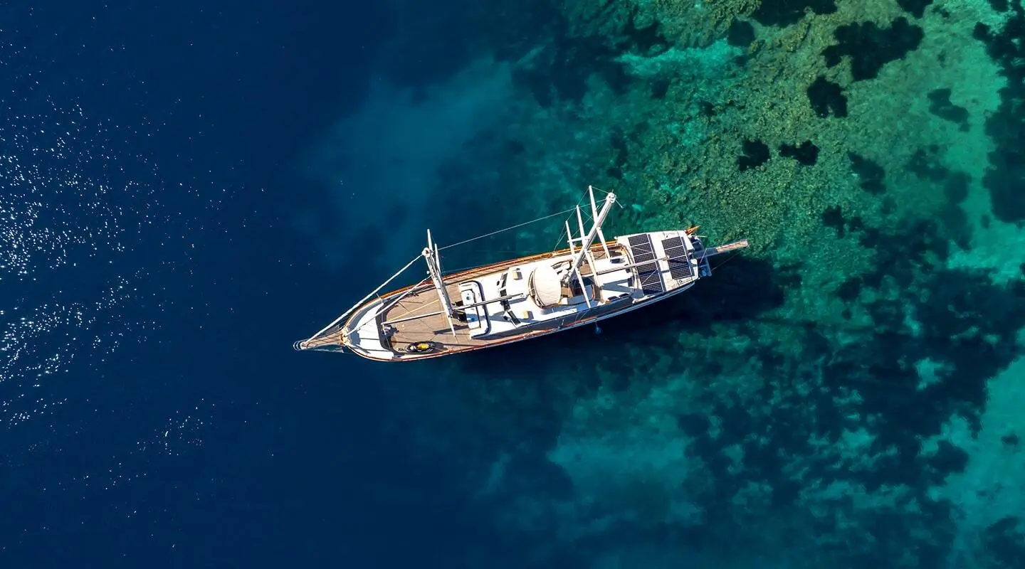 Aerial view of the gulet-style yacht named Double Eagle anchored in clear turquoise water