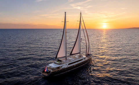 Dalmatino yacht sailing at sunset with three masts on calm sea