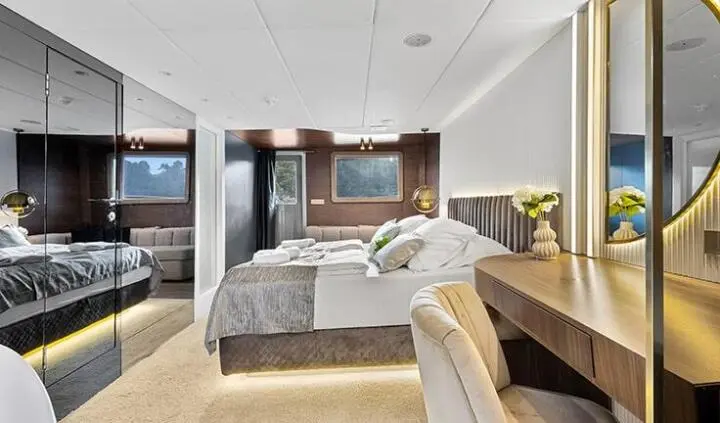 Bella yacht cabin with a large king bed, ensuite, and tan decor