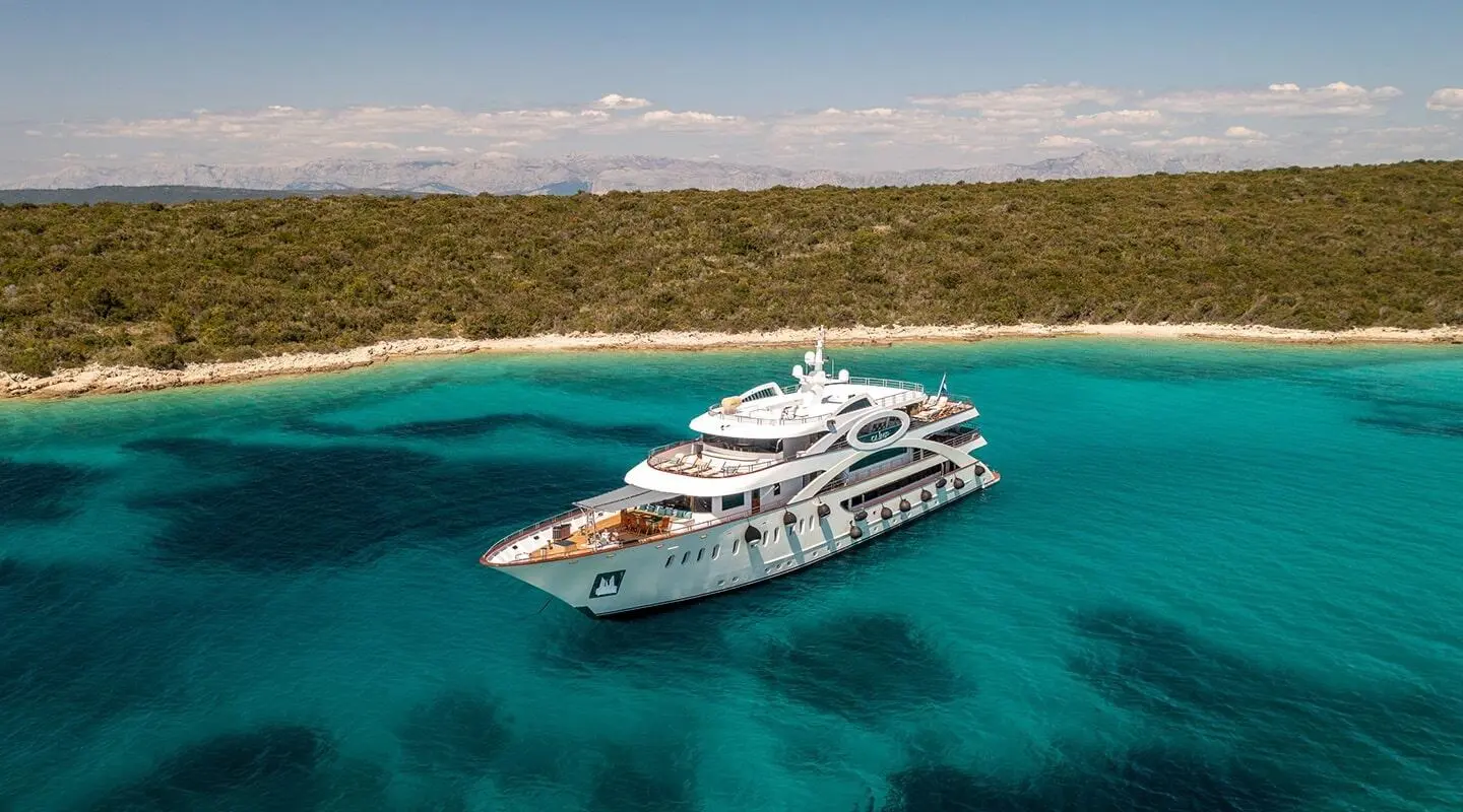Olimp luxury yacht anchored in turquoise waters with calm sea and clear sky
