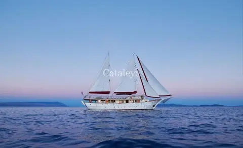 Yacht Cataleya gulet sailing on calm sea with sails unfurled at sunset