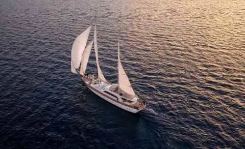 Alessandro I yacht sailing at sunset with sails fully deployed on calm sea