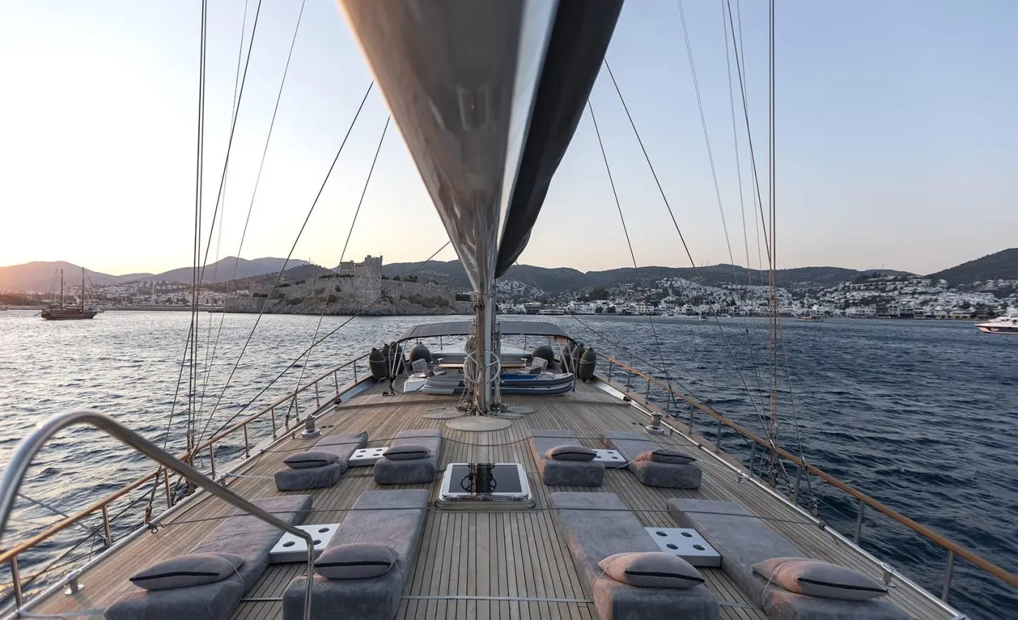 From the deck of Silver Moon, sunlit yacht rails frame a calm sea harboring distant boats