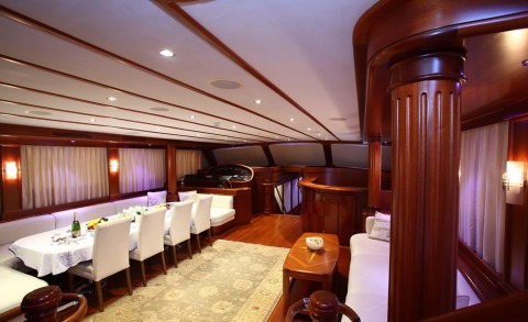 Luxurious gulet saloon with a long white-draped dining table and white chairs