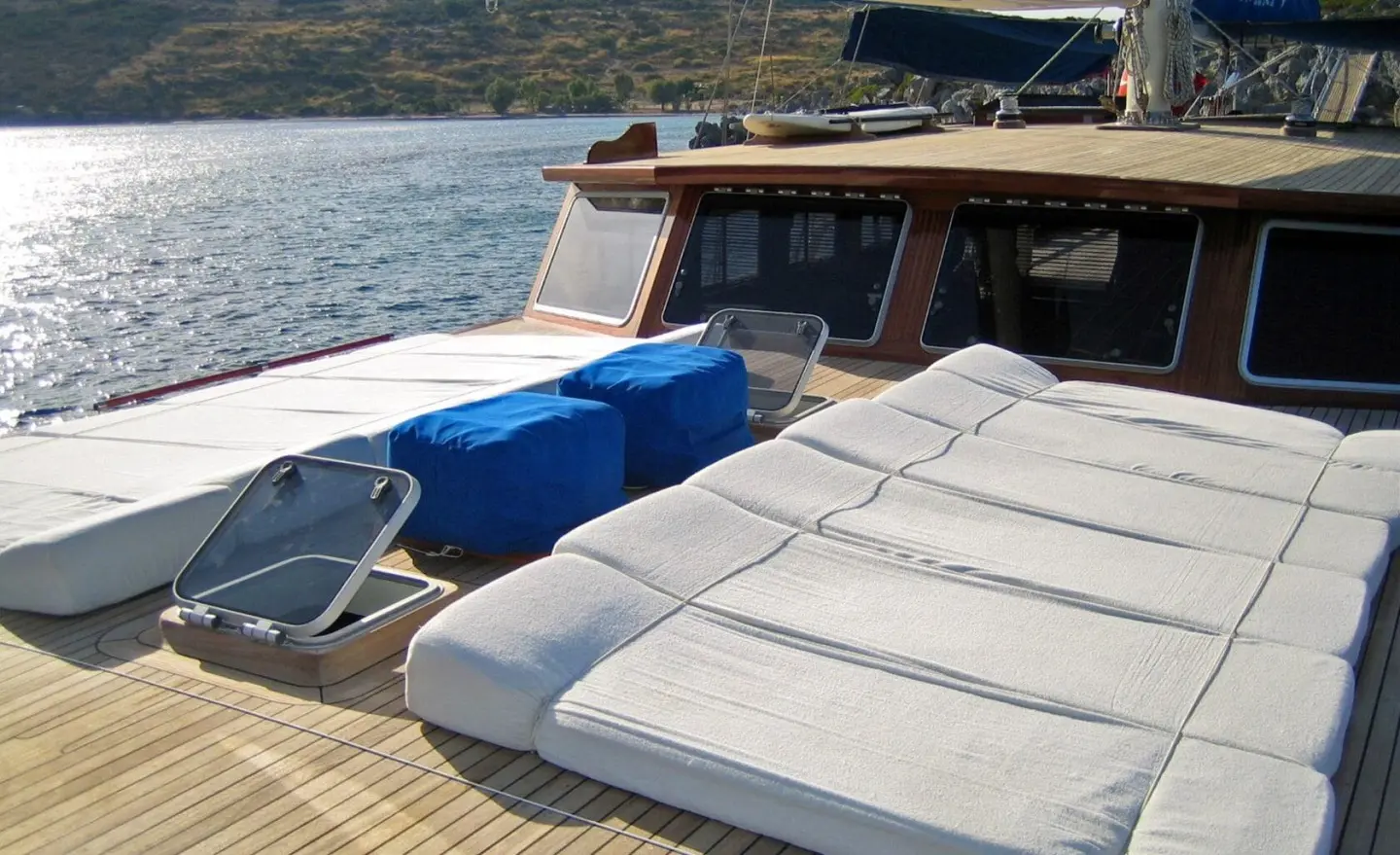 Kaya Guneri 4 yacht deck with sun loungers and blue cushions at sunset