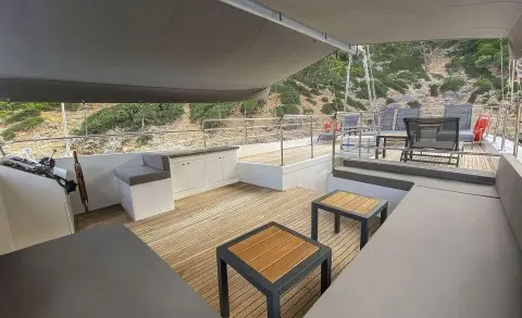 Upper deck seating area of Maske 5 gulet with wooden tables and chairs