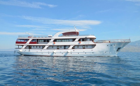 Melody yacht shown with multiple decks cruising on calm blue sea